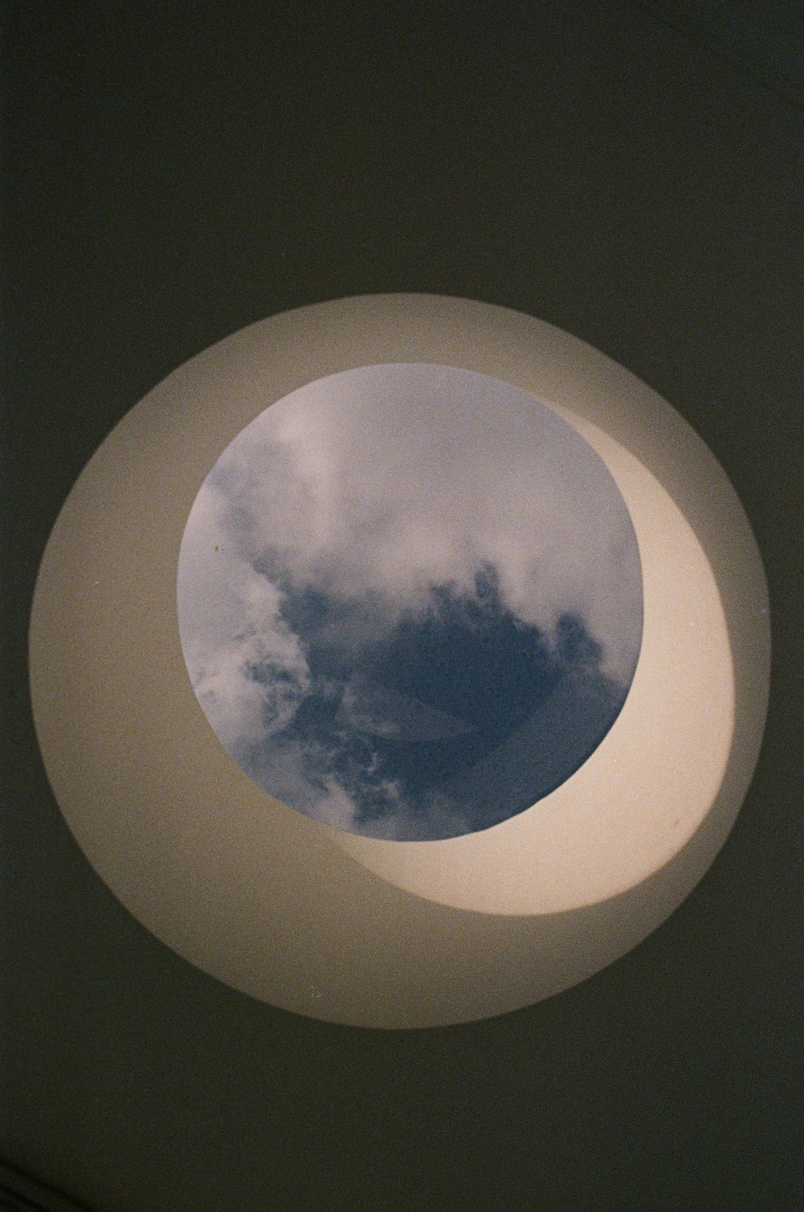 Round skylight framing clouds in the sky above